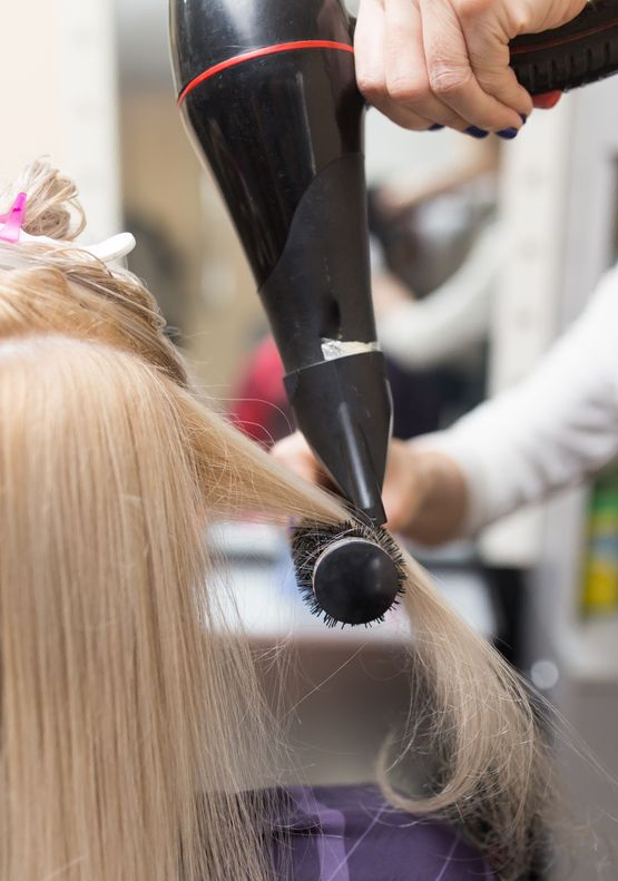 Chica secando el pelo con secador 